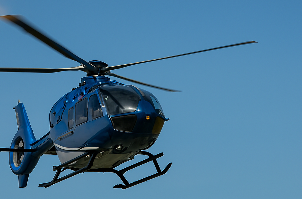 Blue helicopter in flight over clear sky